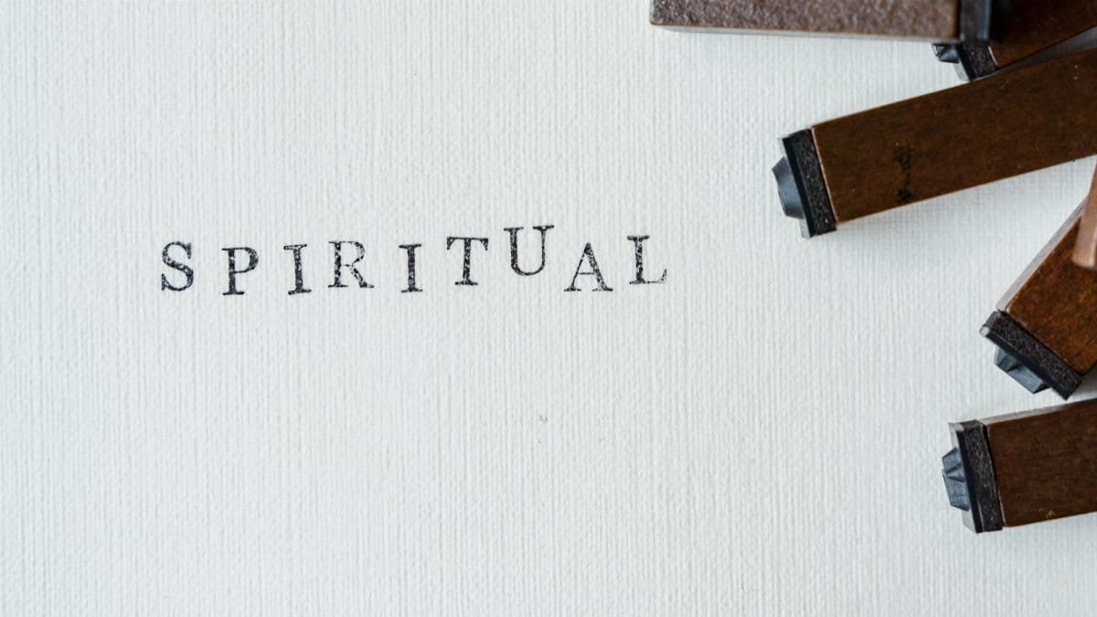Wooden blocks spelling 'SPIRITUAL' on textured white canvas surface.