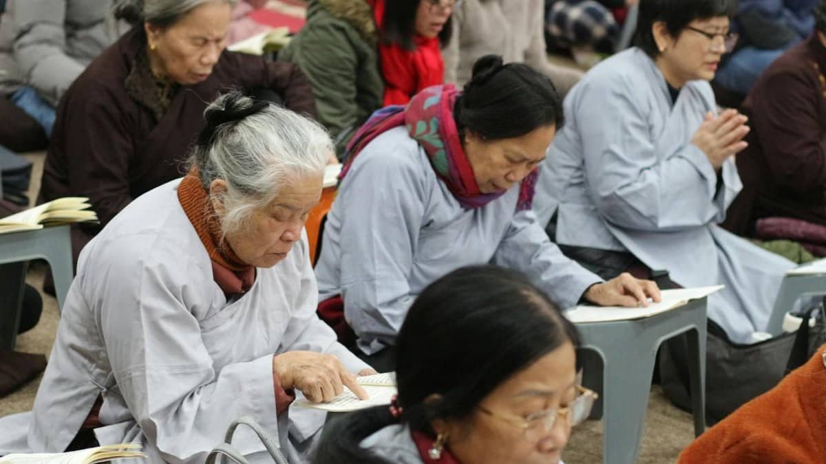 Adults meditating and reading sacred texts in a serene indoor setting, conveying tranquility.