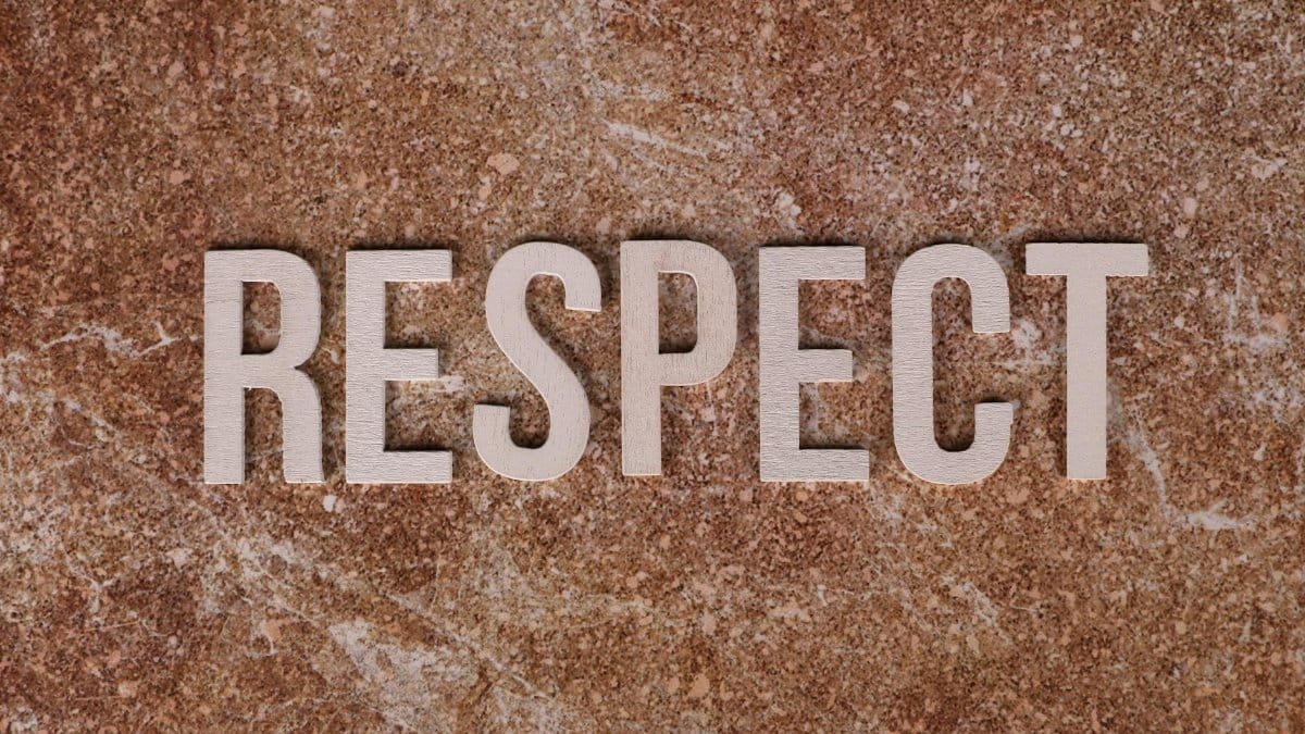 Wooden letters spelling 'RESPECT' on a textured stone surface, conveying a message of dignity and value.