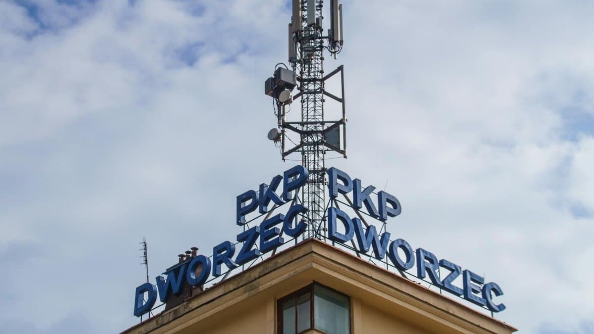 Close-up of PKP train station in Krynica-Zdrój with communication tower against the sky.