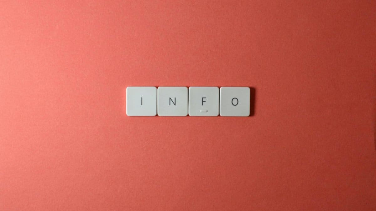 Close-up of keyboard buttons spelling 'INFO' on a minimal red background, ideal for tech and communication themes.