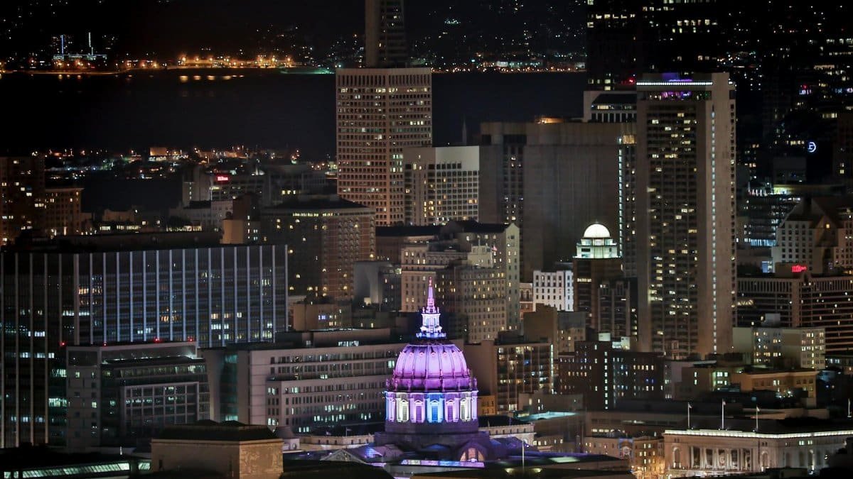 A stunning view of San Francisco skyline at night, featuring a brightly lit dome.