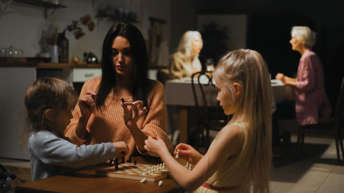 A family enjoys quality time playing chess together, fostering bonding and strategic thinking.