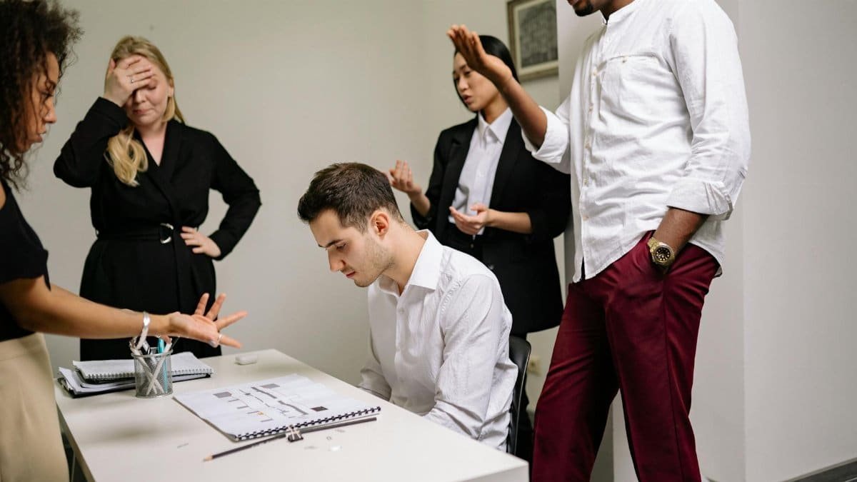 Business professionals engaged in a tense discussion at the office, highlighting workplace conflict.