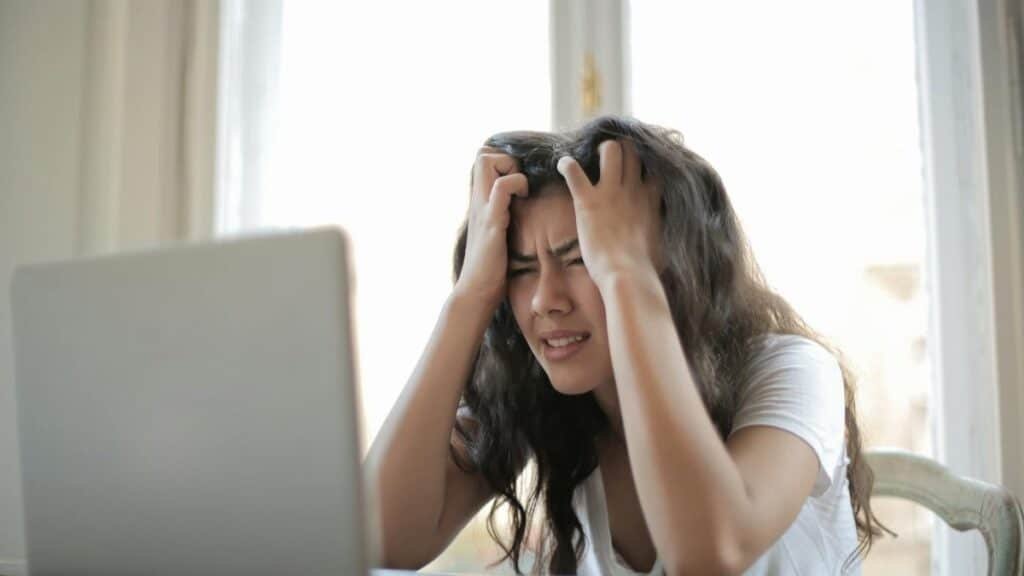 Frustrated woman struggling with remote work stress and digital challenges indoors.