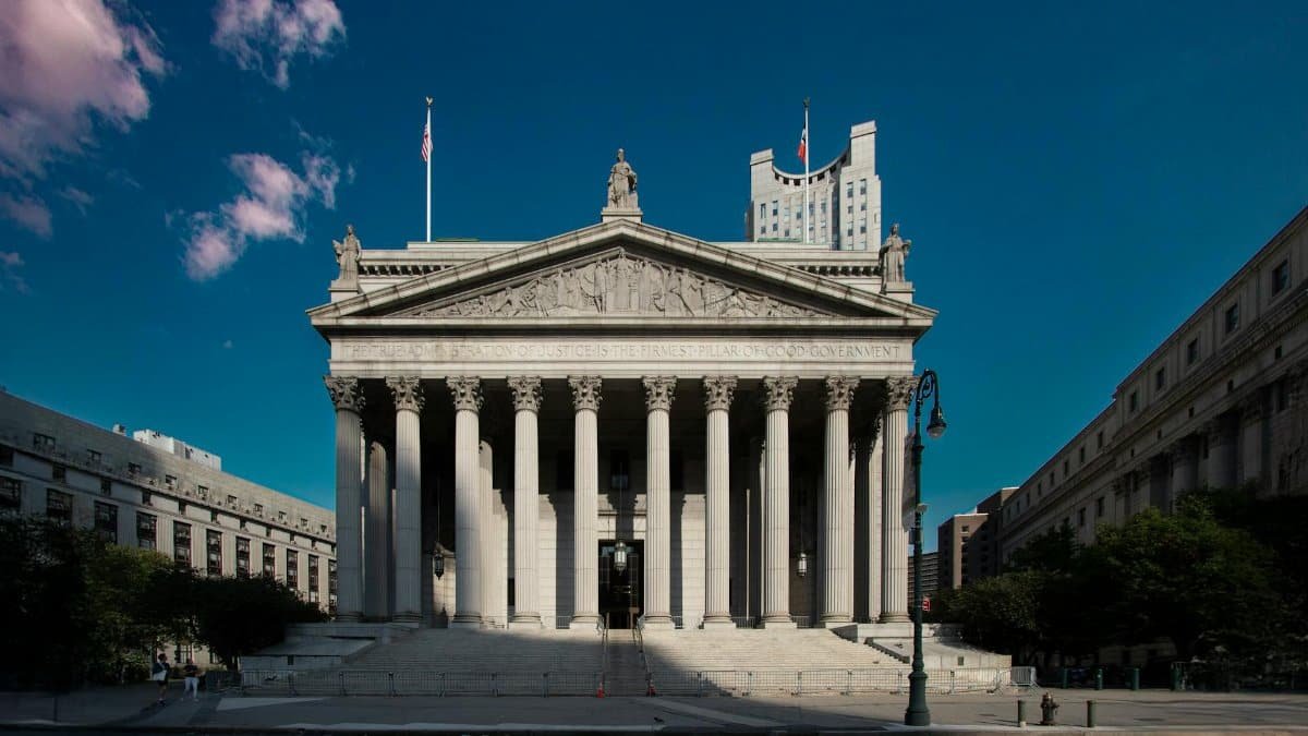 Front view of the Supreme Court building in New York City with blue skies.