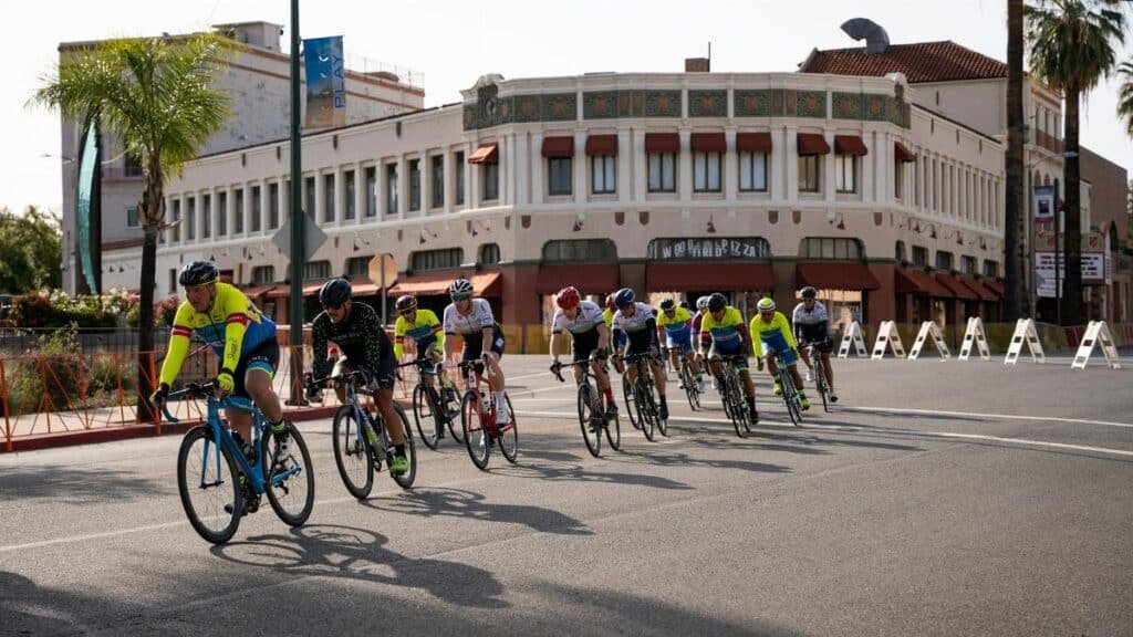 Group of cyclists in a street race through downtown Redlands, CA.
