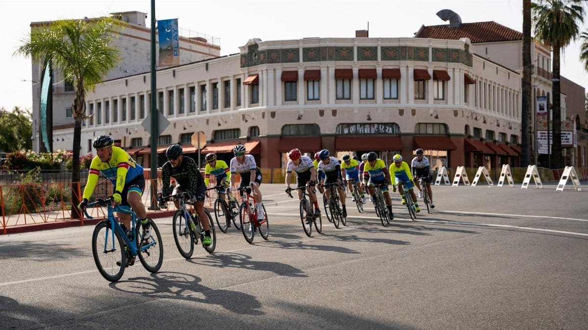Group of cyclists in a street race through downtown Redlands, CA.