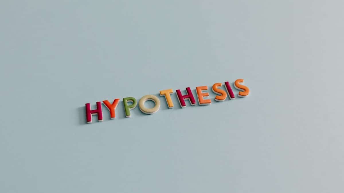 Multicolored letters spell 'HYPOTHESIS' on a light blue surface, conveying research and creativity.
