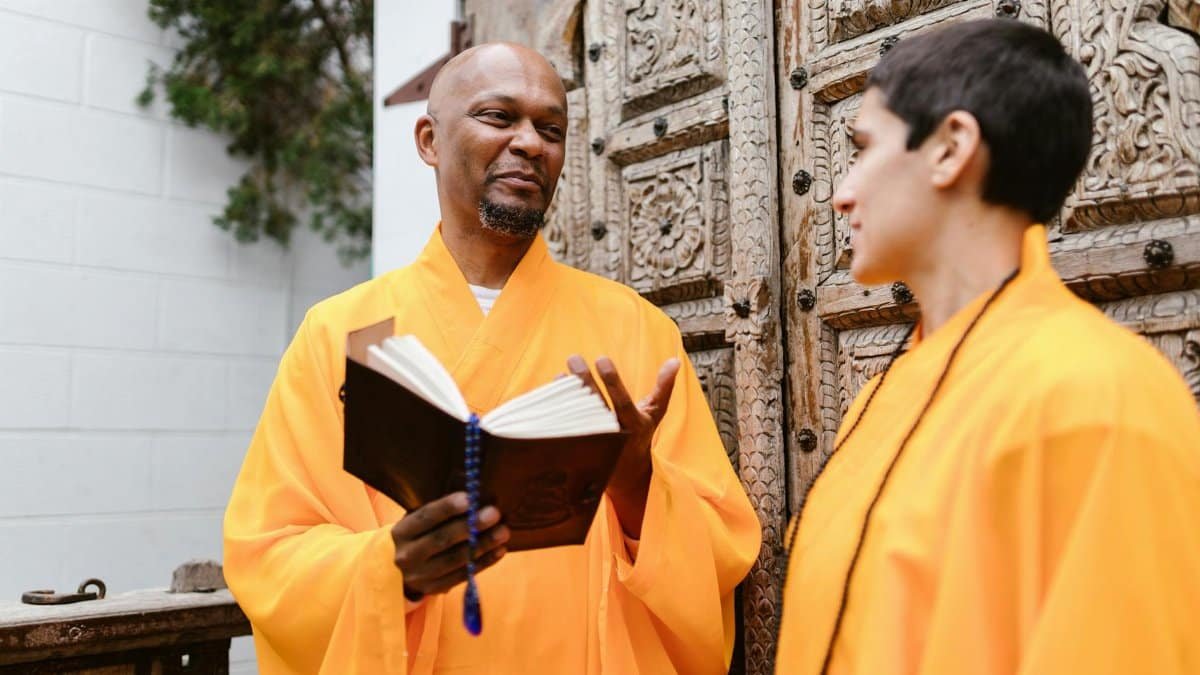 Buddhist monks in vibrant robes sharing a peaceful outdoor conversation, fostering spirituality.