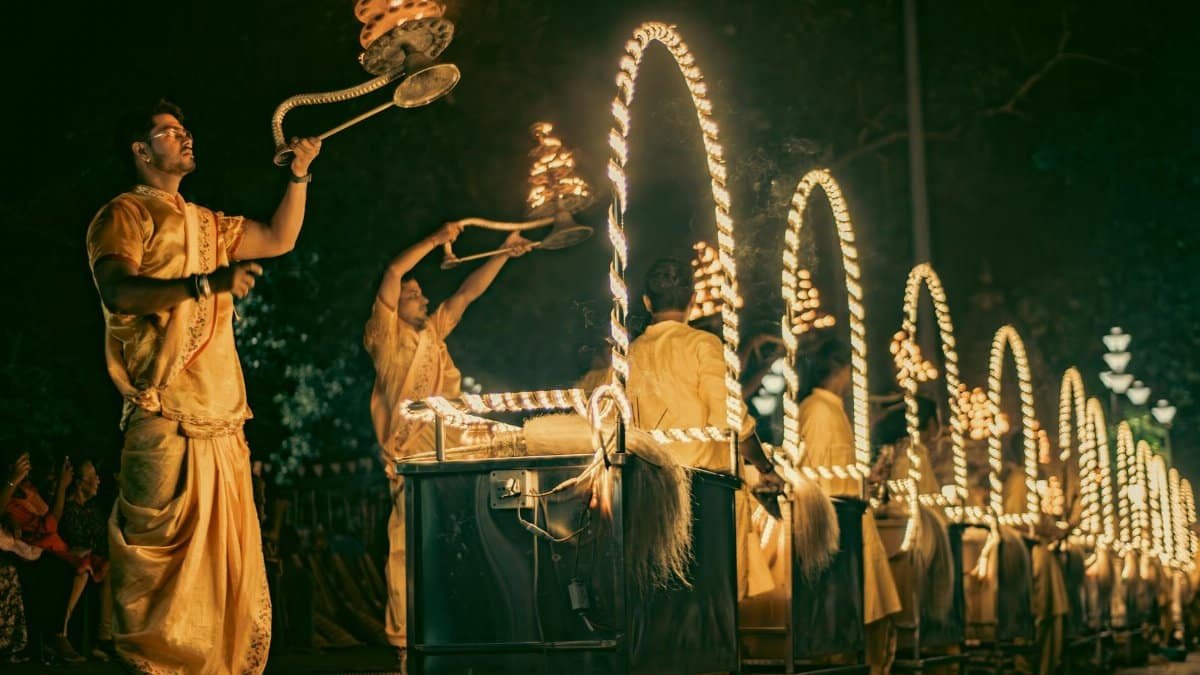 Traditional Aarti ceremony at night with priests performing rituals holding lit lamps, creating a spiritual ambiance.