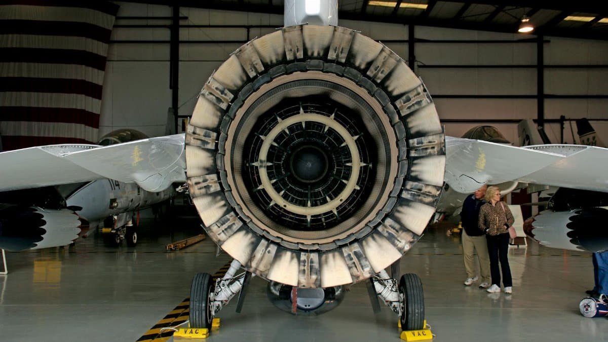 Detailed photograph of a jet engine exhaust with visible technical components inside a hangar.