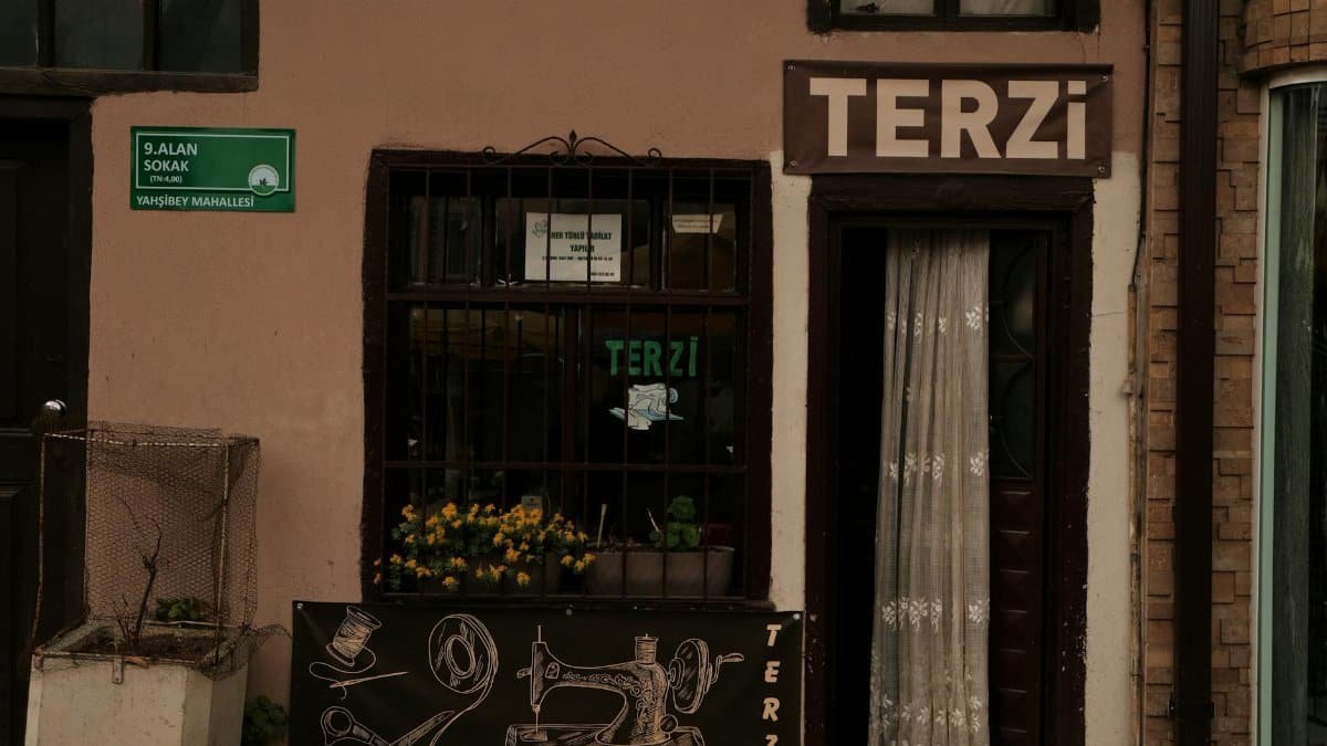 Charming facade of a tailor shop with vintage sewing decor and signage in an urban setting.