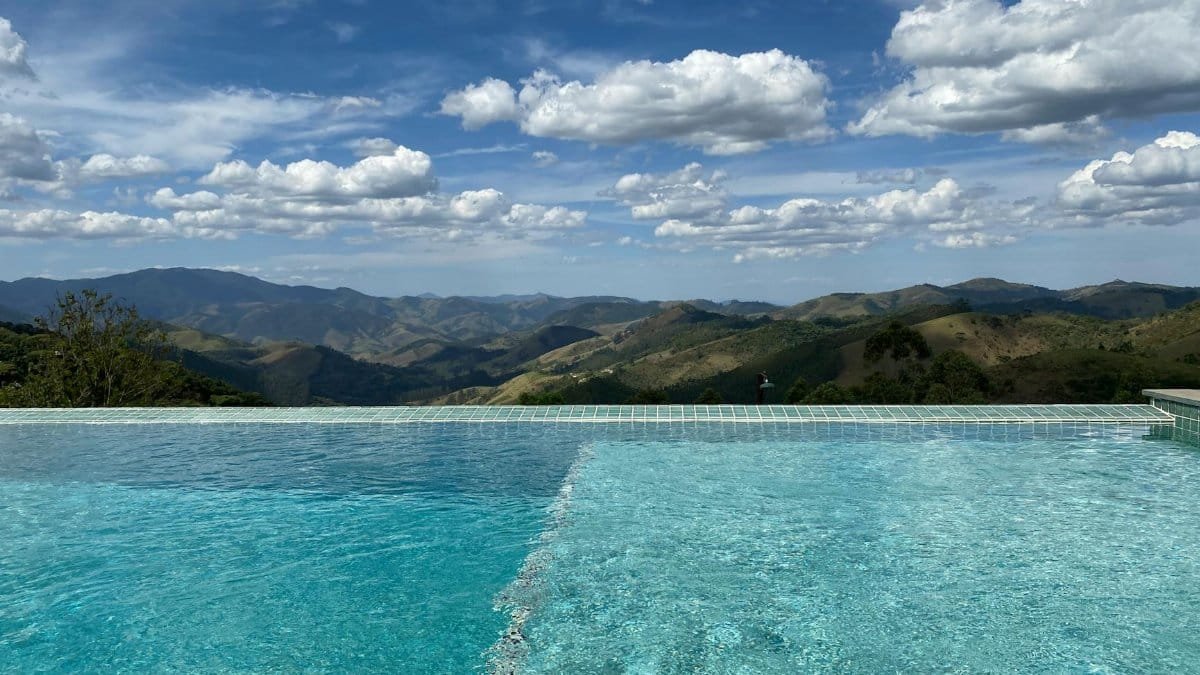 Stunning infinity pool with panoramic mountain views under a bright sky.
