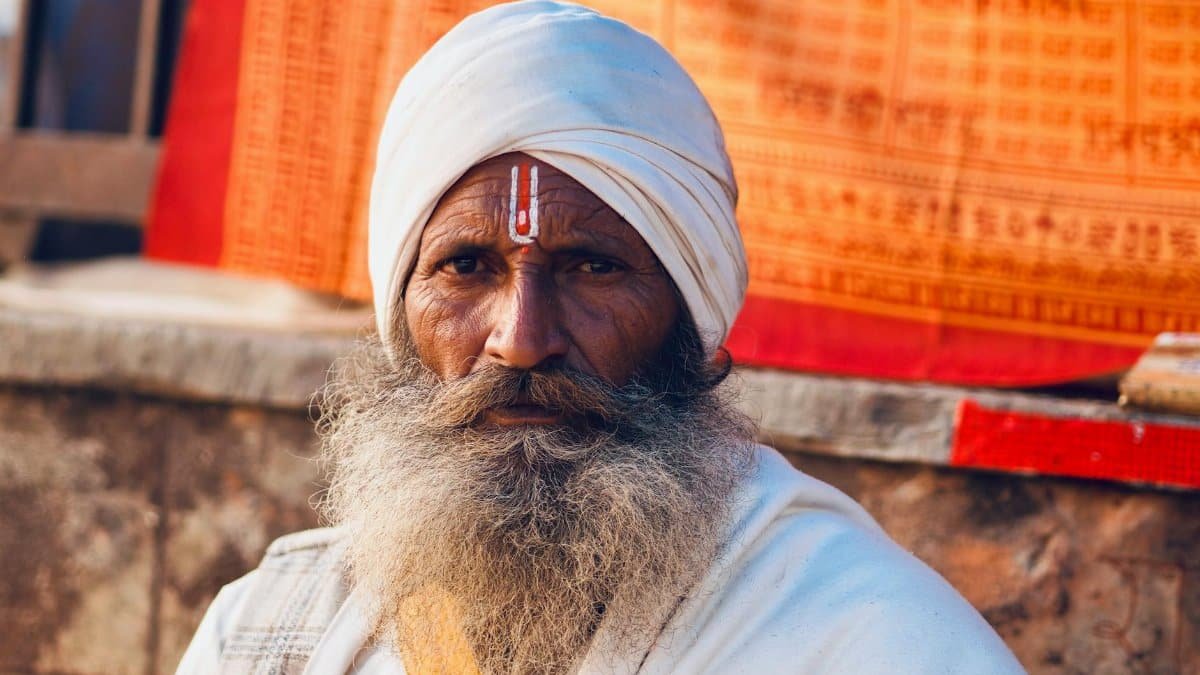 A portrait of a senior man in traditional clothing, embodying spiritual devotion.