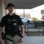 A security guard patrolling an outdoor area in League City, Texas, ensuring safety during the day.