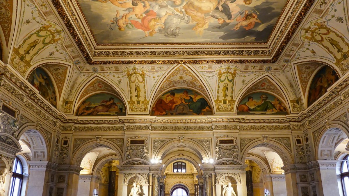 Intricately decorated museum interior showcasing a grand frescoed ceiling and elegant architecture.