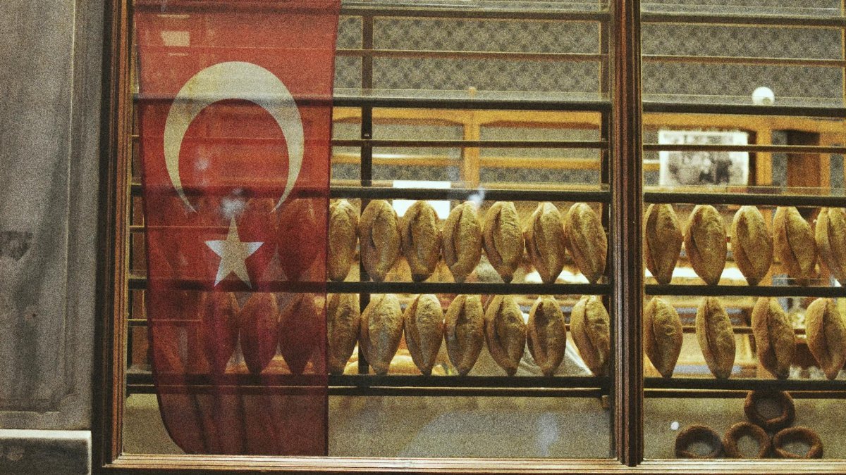 A Turkish bakery window showcasing fresh bread and a Turkish flag, creating a warm ambiance.