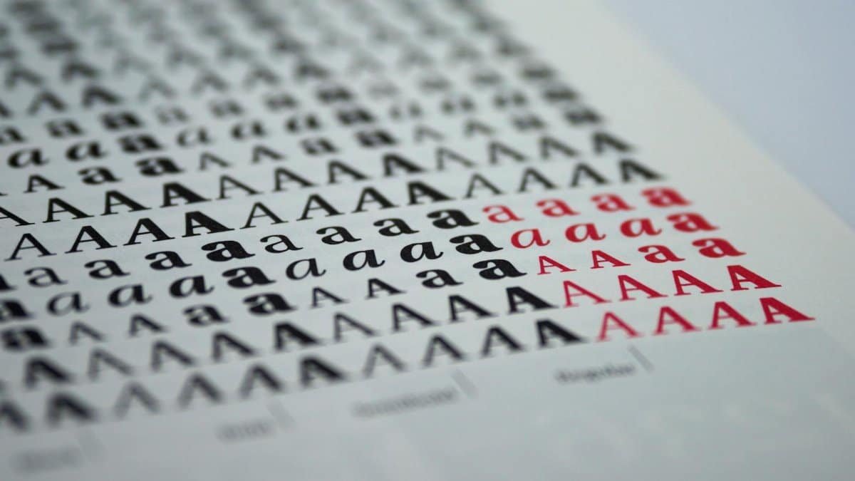 Close-up view of various printed letter 'A' styles in black and red on white paper.