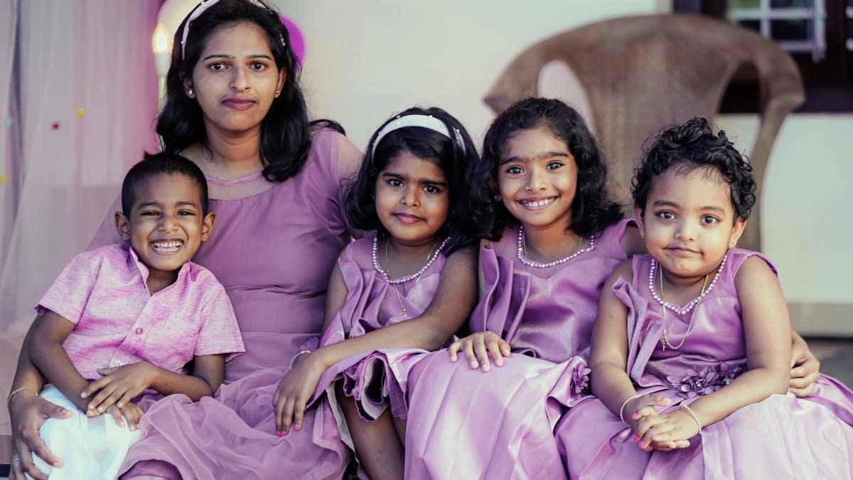 A happy mother with her children posing in coordinated purple outfits, showcasing family love.