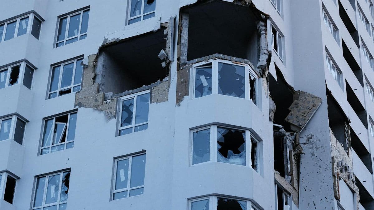 A high-rise building in Ukraine with significant structural damage and shattered windows.