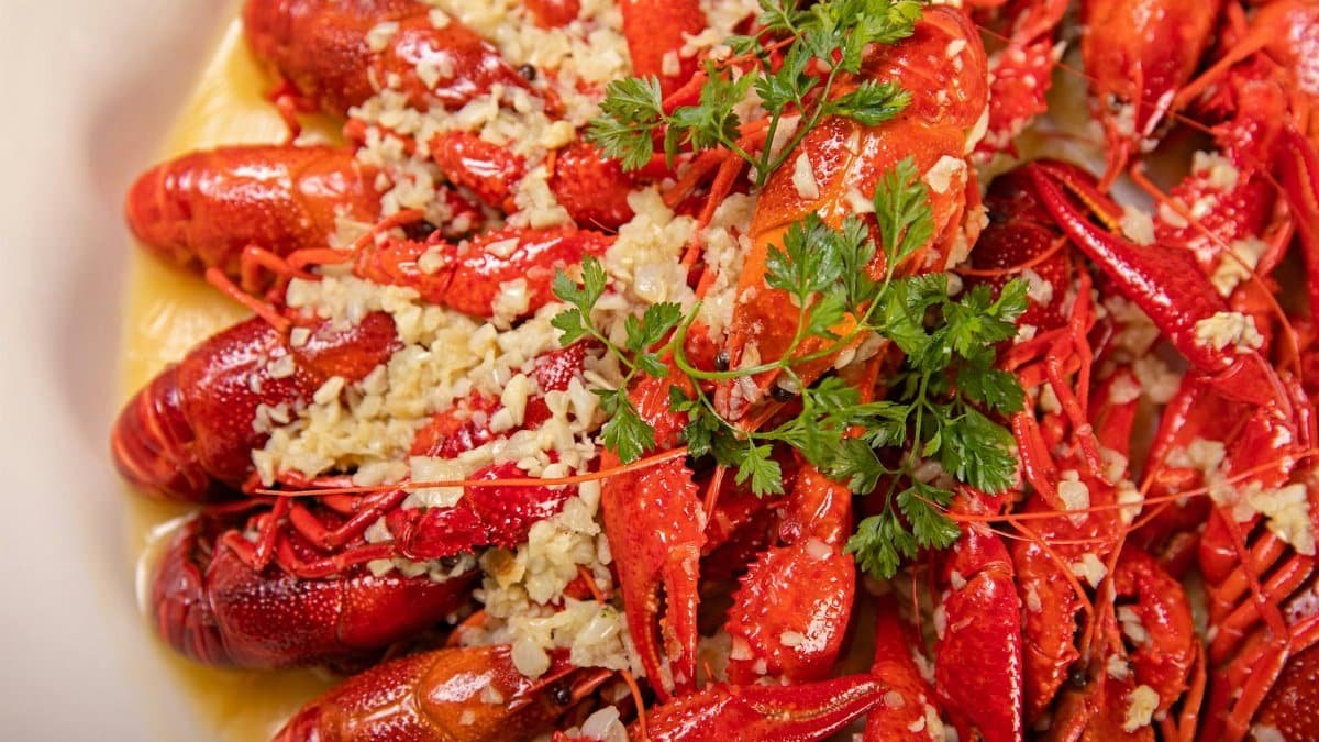 Mouth-watering Cajun crawfish boil garnished with fresh herbs and garlic butter.