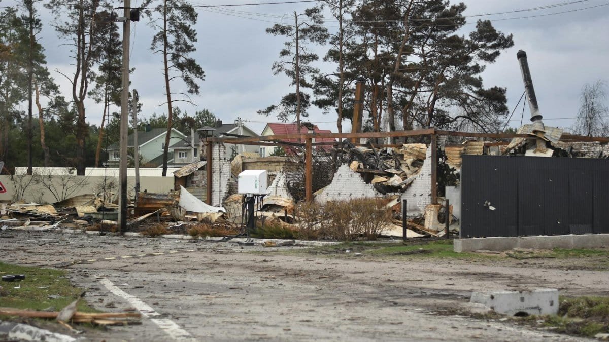 A burnt residential area with collapsed structures indicating recent devastation.