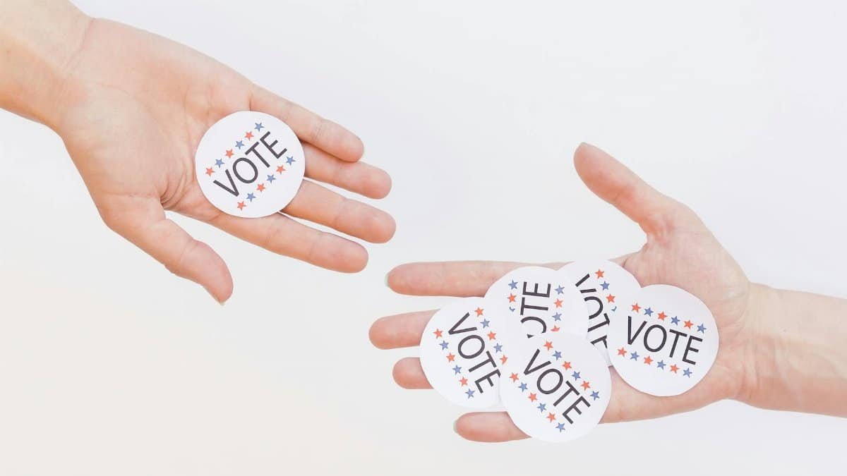 Close-up of hands holding election vote stickers, symbolizing participation.