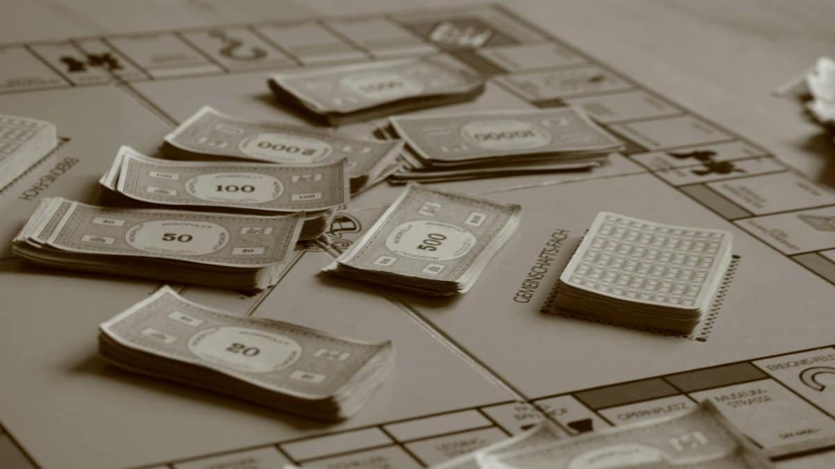 Close-up of board game with play money in sepia tone, focusing on strategic play.