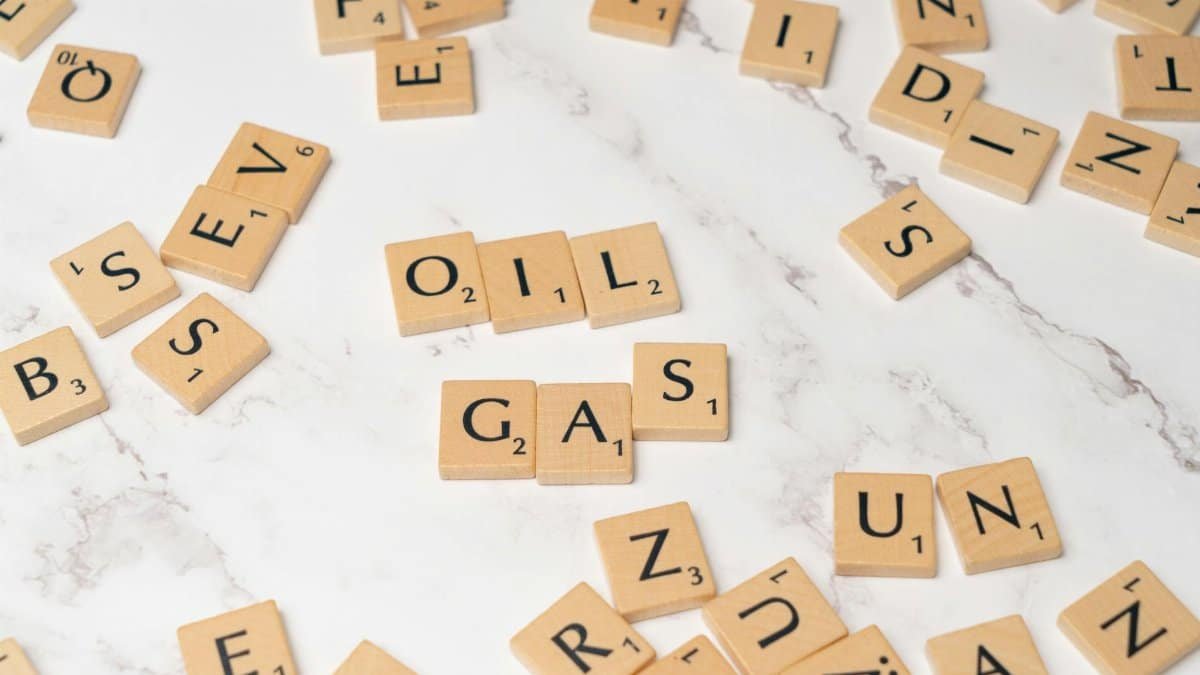 Scrabble tiles on marble spelling 'oil' and 'gas', concept for energy and creativity.