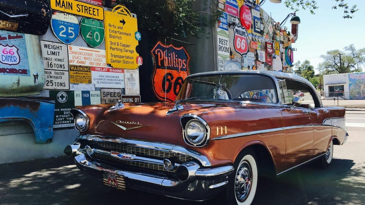 Classic Chevrolet car parked with Route 66 signage in Albuquerque, New Mexico. Nostalgic travel scene.