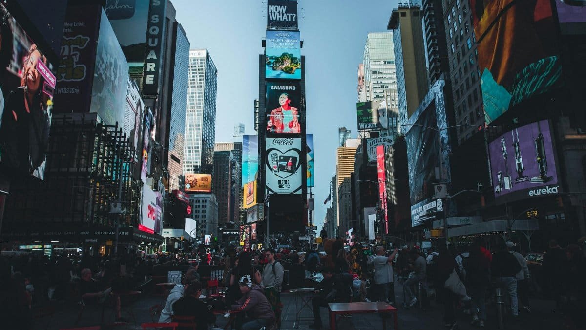 Vibrant Times Square in New York City filled with people and bright billboards during the day.