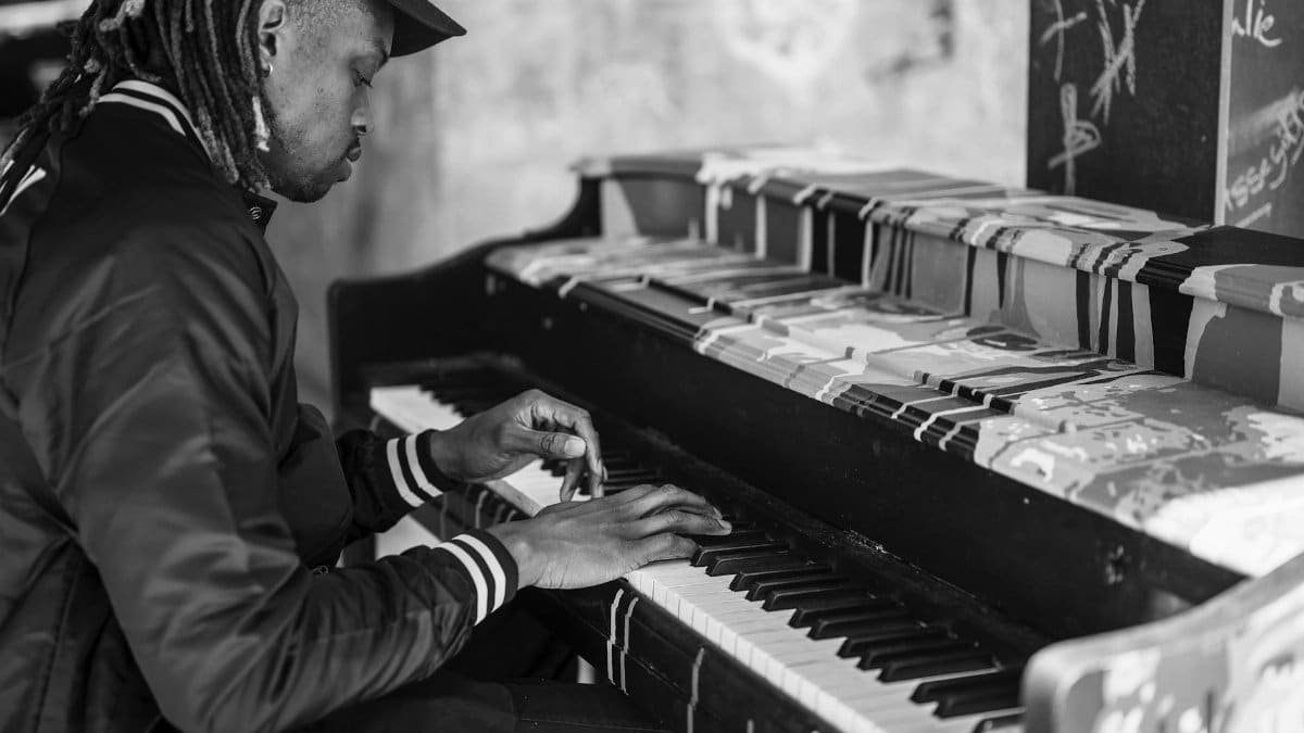Captivating monochrome image of a man playing an urban street piano.