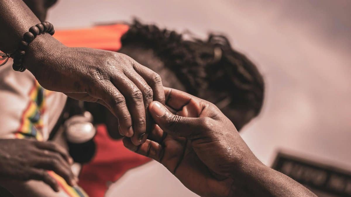 Detailed close-up of hands interacting outdoors, with a blurred background suggesting connection.