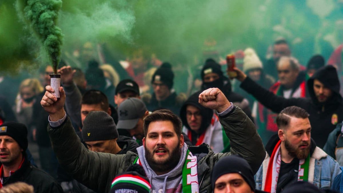 A vibrant crowd of football fans celebrating with smoke flares, showcasing passion and unity.