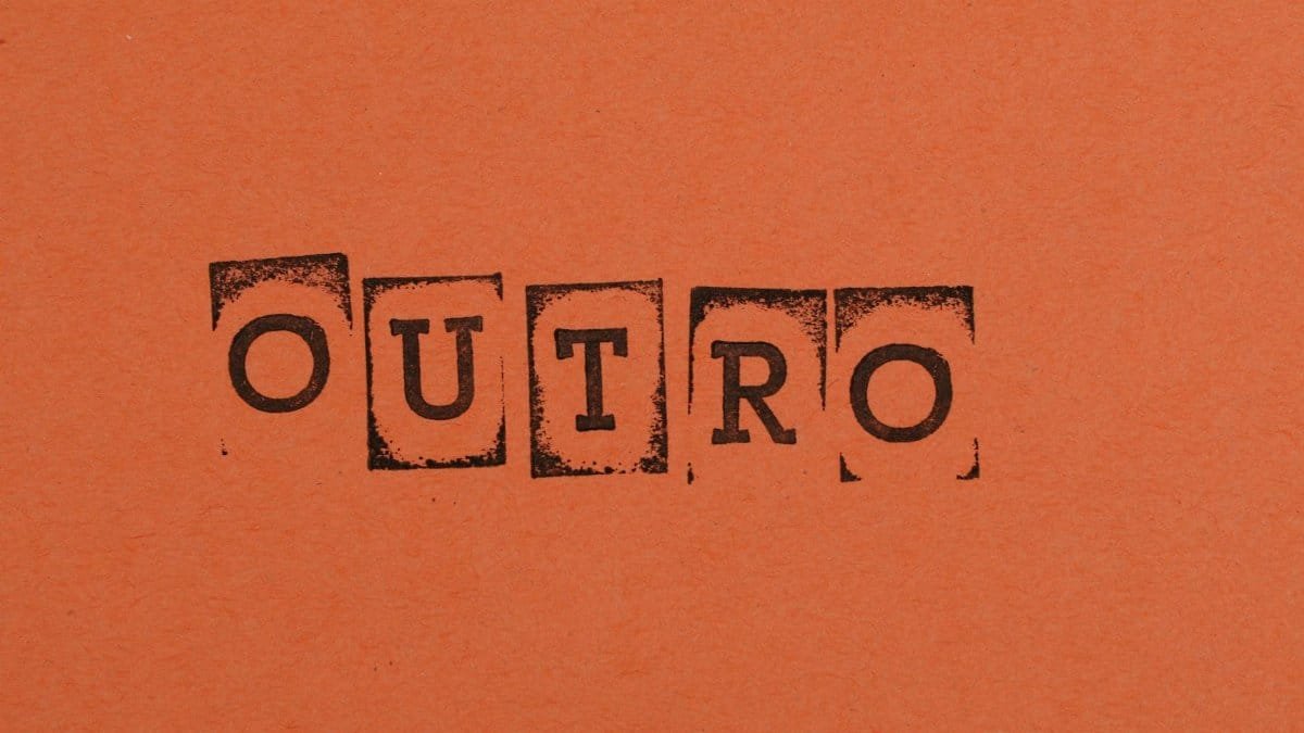 Close-up of the word OUTRO stamped on orange paper, highlighting typography and design.