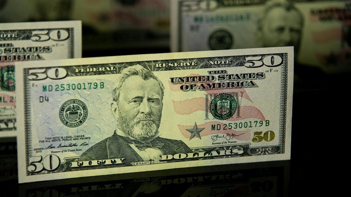 Detailed close-up of a US fifty dollar bill, emphasizing currency design and wealth theme.