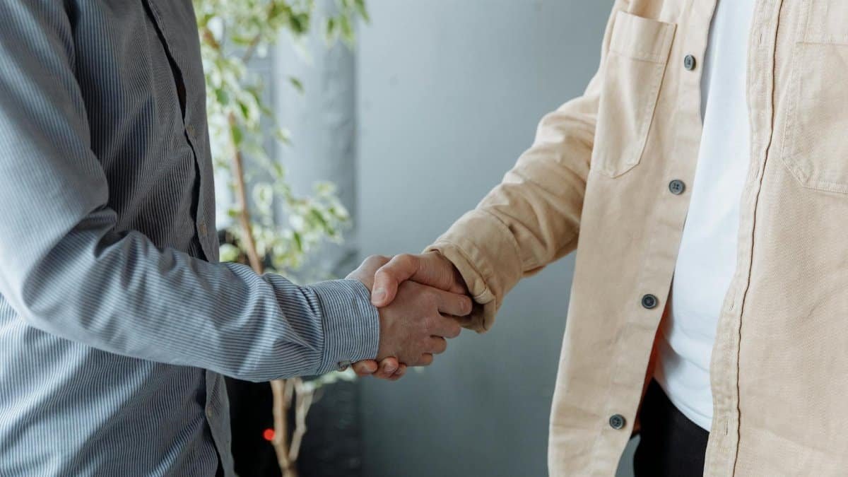 A close-up image of two businesspeople shaking hands in an office environment symbolizing agreement and partnership.