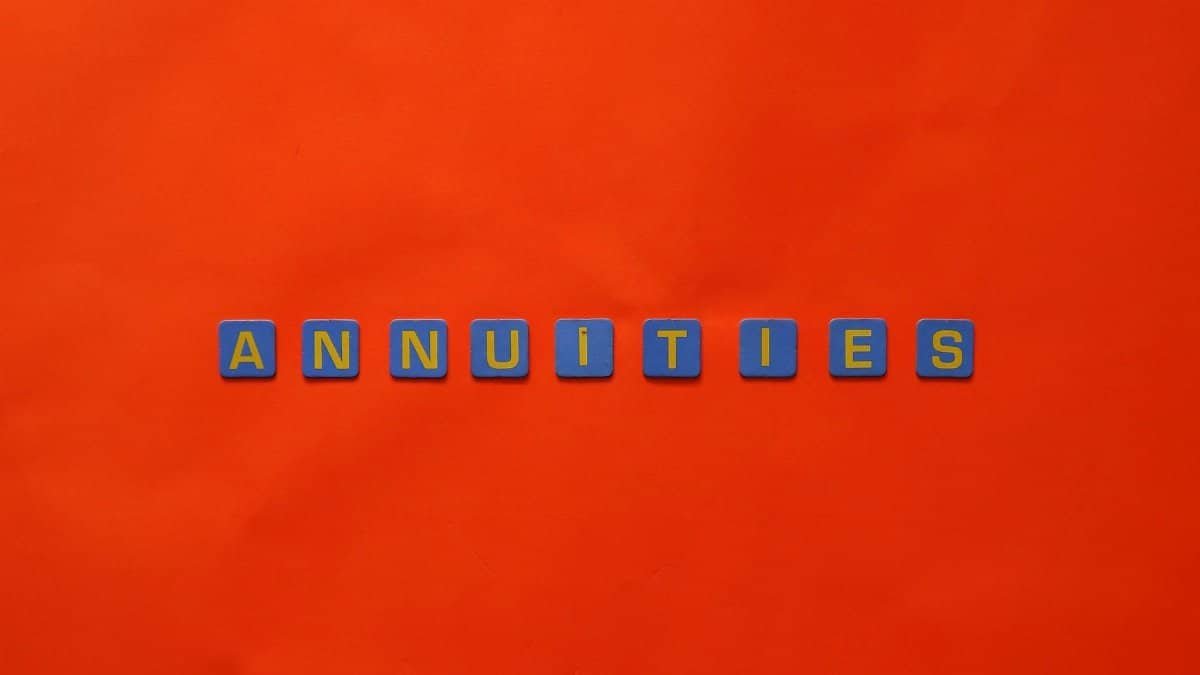 Conceptual image of the word 'Annuities' spelled with tiles on a vibrant red background.