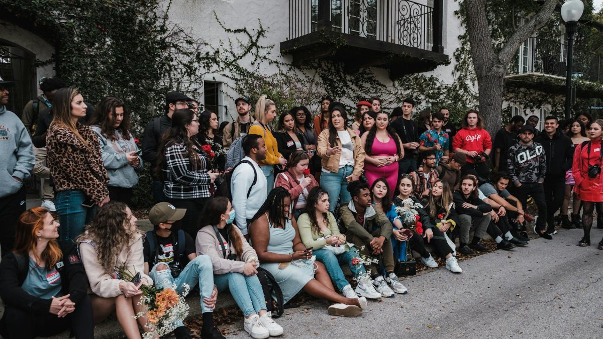 A large group of diverse people gathered outdoors in Winter Park, FL, showcasing community and togetherness.