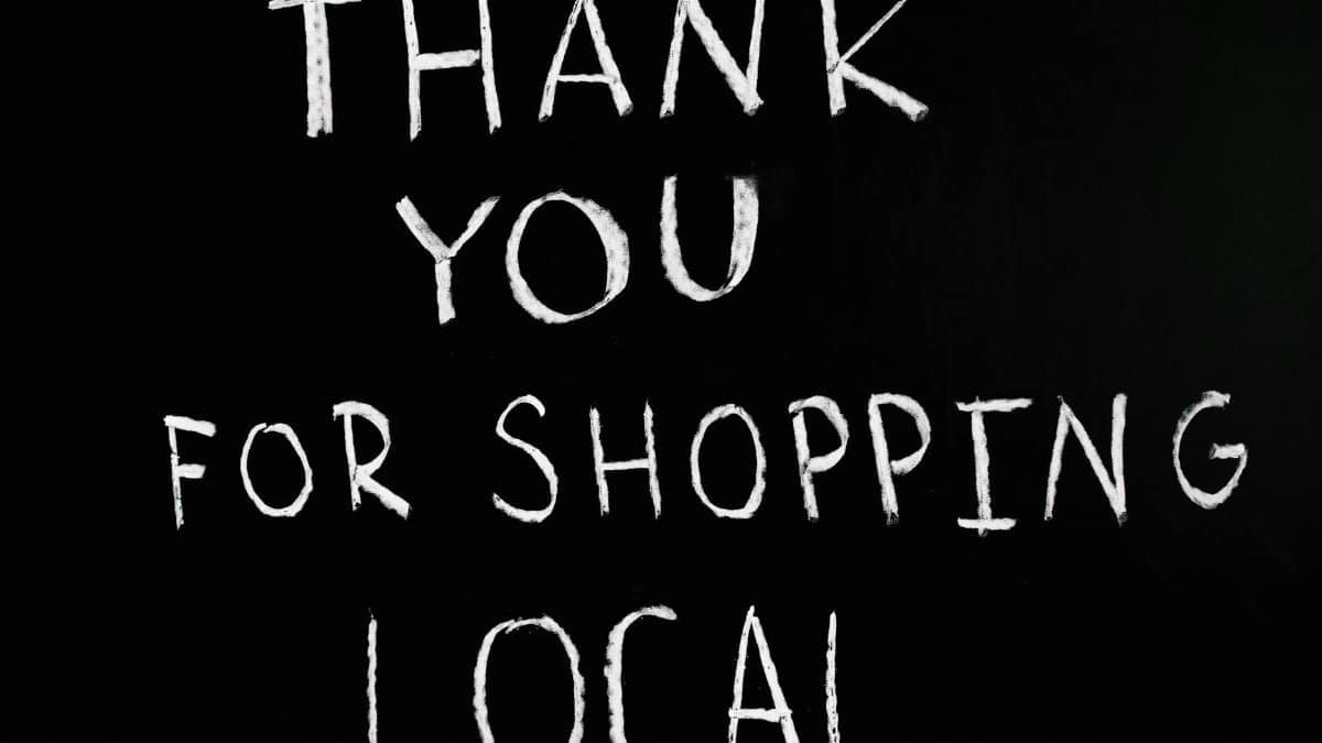 A chalkboard with handwritten message thanking for supporting local businesses.