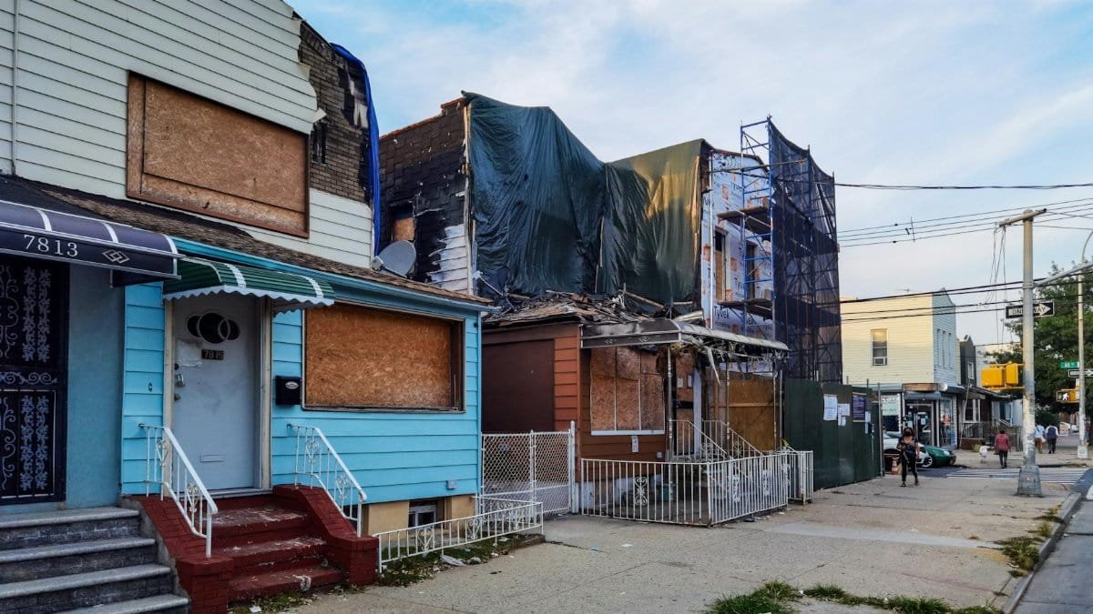 Boarded-up houses showing decay in Queens, New York.