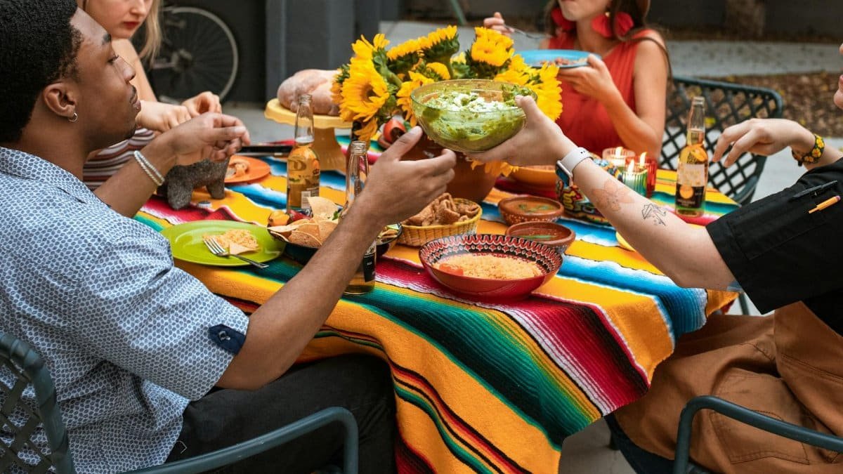 A vibrant and lively outdoor dining scene with friends enjoying a meal and drinks.