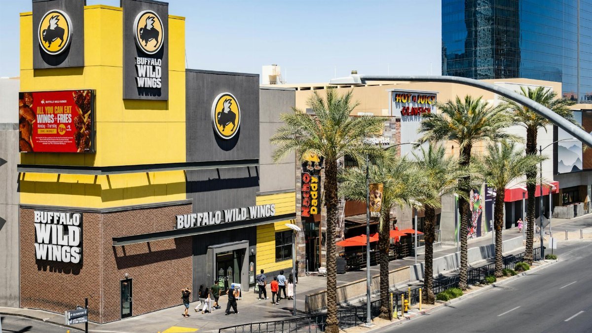 Buffalo Wild Wings located on the bustling Las Vegas Strip with palm trees and pedestrians.