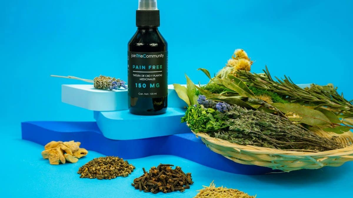 A black spray bottle of herbal pain relief with natural ingredients on a blue background.