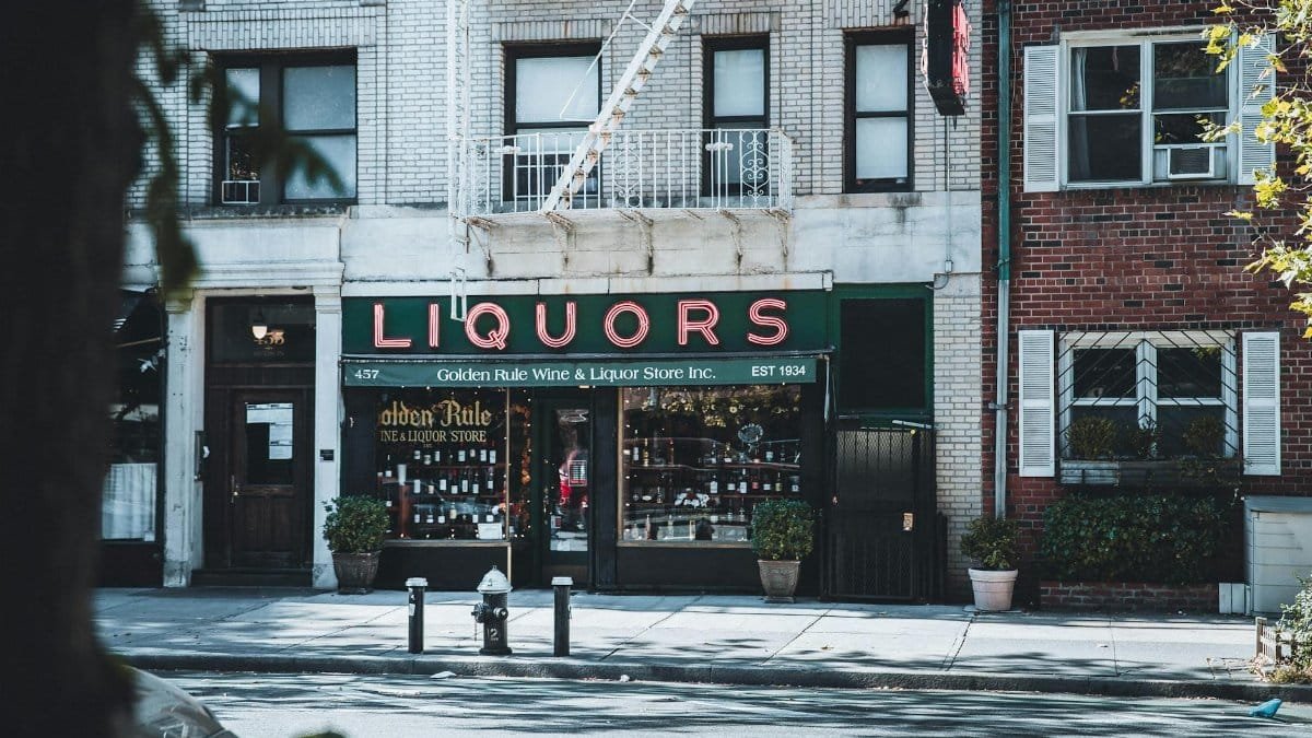 Vintage New York City liquor store facade with architectural details on a sunny day.