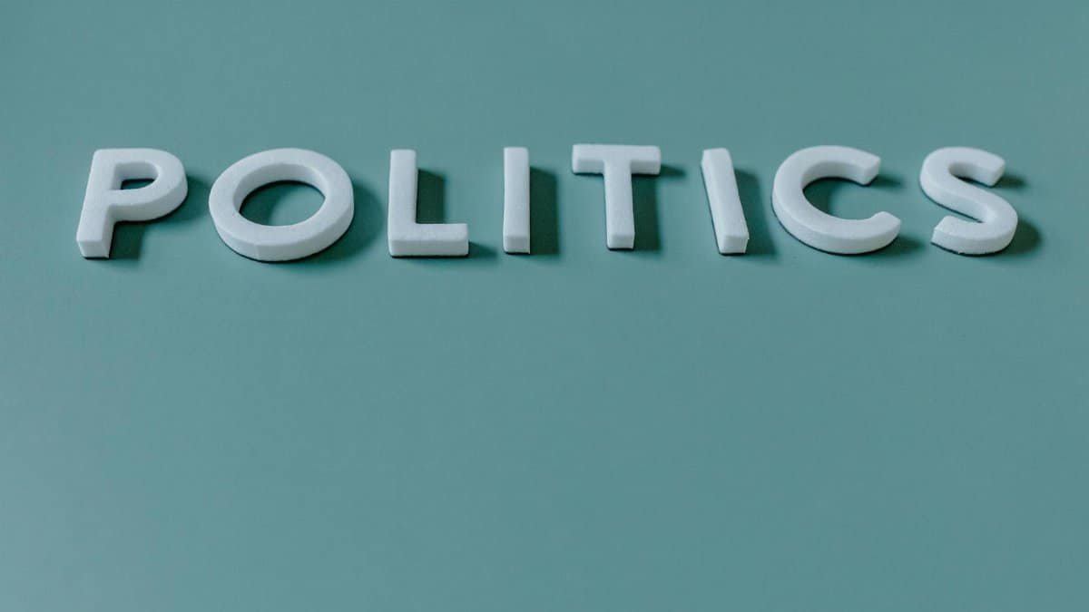 Close-up image of the word 'Politics' against a teal green background, highlighting political themes.