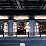 A stylish urban street scene at night with a modern lit building facade.