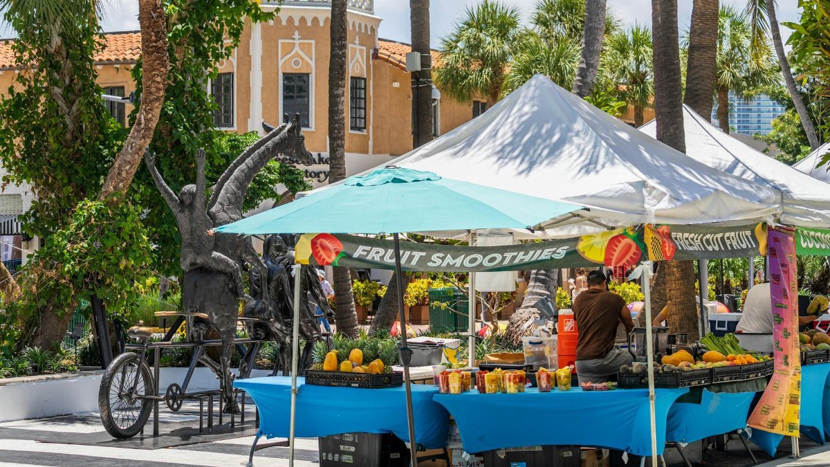 Fruit stalls under sunny skies in Miami Beach, featuring tropical produce and local art.