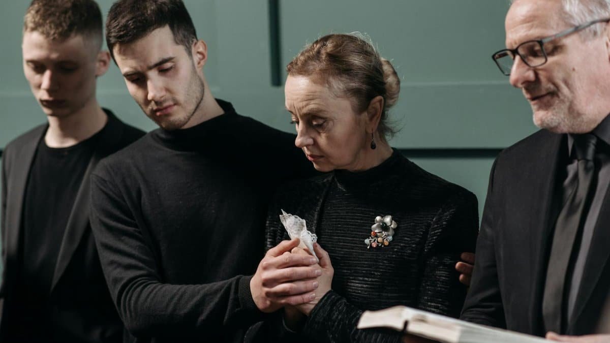 A poignant moment captured during a memorial service showing emotional support.